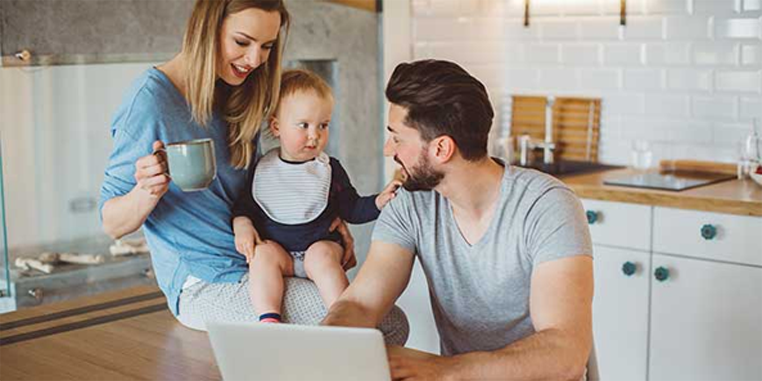 Couple with baby looking at laptop