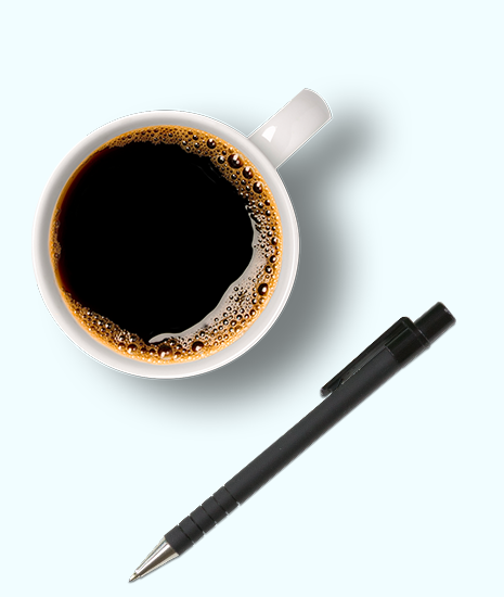 A cup of coffee and a pen on a table.